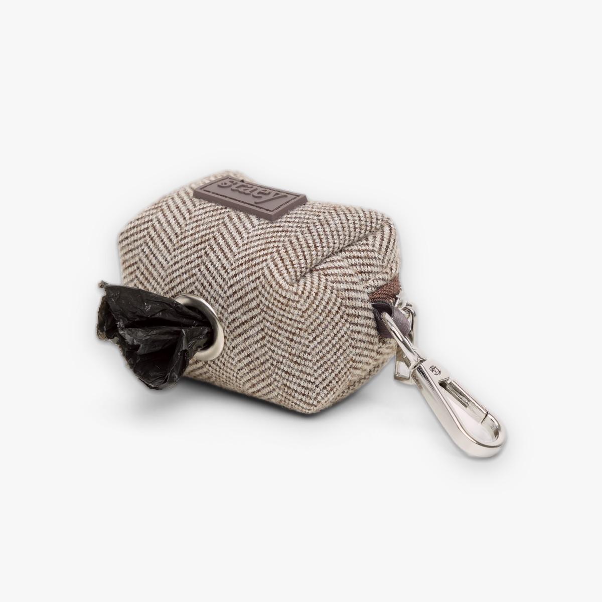 Elma poop bag holder dispensing a waste bag through its opening